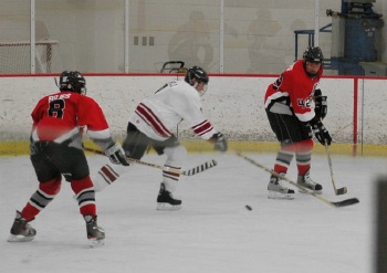 Center John Rajes (8) and left wing Ben Tesch (42) play keepaway with the Outlaws defense.