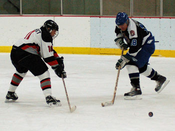 Captain Carlos Eberhardt successfully poke checks the puck. Photo: Julie Berris