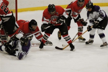 Battling for the puck in front of goalkeeper Jeff Keacher.