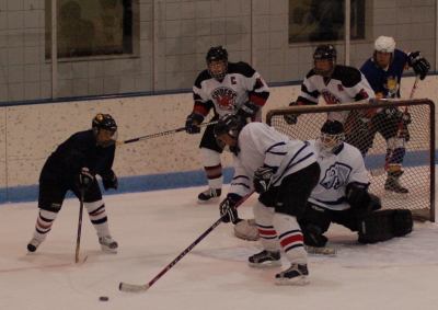 Defenseman Matt Essary pokes the puck, as Carlos Eberhardt (11), Bob Jensen (5) and Goalkeeper Chris Trinh look on, in the Oct. 13 game vs. the Fighting Saints.