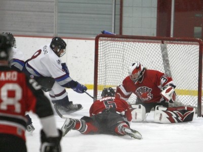 Luke Baker (6) taking a rest, while netminder Amber Obermoller (34) cleans up.