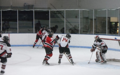 Litton (14) watches the puck into Obermoller’s (34) glove, while Gustafson (10) and Ackermann backcheck.