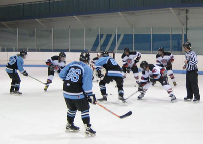 John Pellicci (50) takes a faceoff, while Heitzman (27), Herman (4) and LaCosse (26) support.