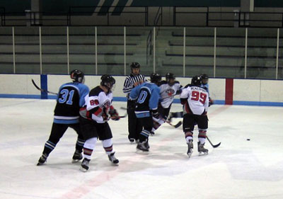 Ackermann (99) wins the center-ice faceoff, with Schlais (88) and newly returned Ungaro (19) support.