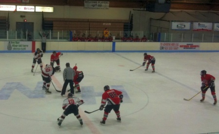 Coach Hilden presides over the bench during third-period faceoff.